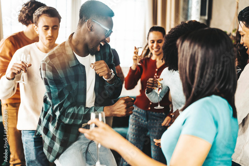Diverse group of friends having home party together - Funny young people having fun dancing and singing in the living room - Youth lifestyle concept