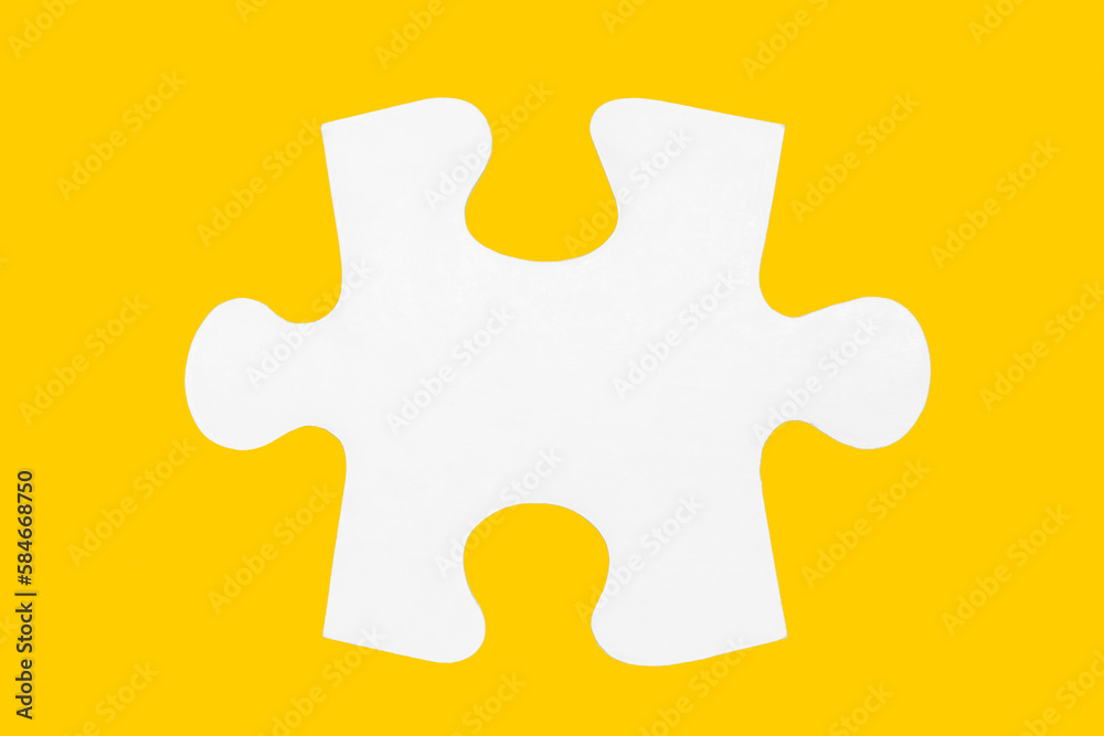 Fototapeta premium Closeup of jigsaw puzzle piece isolated on yellow background