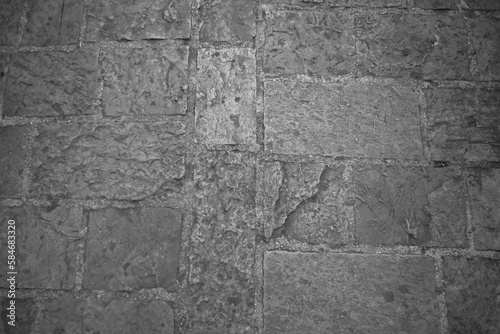 Cobblestone tiles street with big stones, top view. Ancient stone floor. Old pavement for a poster, calendar, post, screensaver, wallpaper, postcard, cover, web. Gray toned high quality photo
