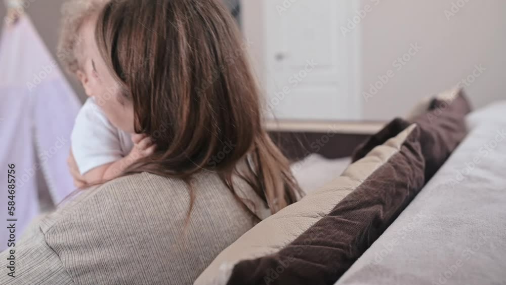 mother holds a curly-haired baby in her arms. Hugs and kisses him. Slow motion mother holds a curly-haired baby in her arms. Hugs and kisses him. Slow motion