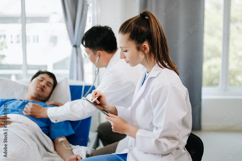 Two doctors talking to a patient lying in his bed with receiving saline solution in hospital . Two doctors talking to a patient lying in his bed with receiving saline solution in hospital .