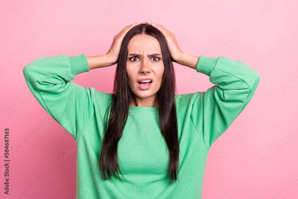 Photo of terrified horrified woman with straight hair dressed green sweatshirt hold arms on head isolated on pink color background - obrazy, fototapety, plakaty 