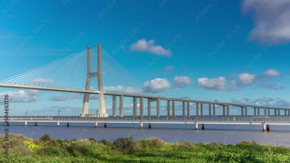 The Vasco da Gama Bridge timelapse hyperlapse. Cable-stayed longest bridge flanked by viaducts and rangeviews that spans the Tagus River in Park of Nations in Lisbon, the capital of Portugal The Vasco da Gama Bridge timelapse hyperlapse. Cable-stayed longest bridge flanked by viaducts and rangeviews that spans the Tagus River in Park of Nations in Lisbon, the capital of Portugal