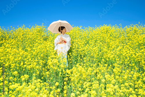 Japanese woman in a beautiful yellow flowers field