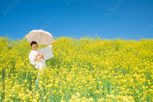 Japanese woman in a beautiful yellow flowers field