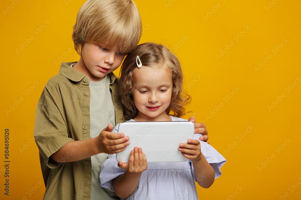 Kids using digital multimedia technologies, children standing with a tablet Kids using digital multimedia technologies, children standing with a tablet