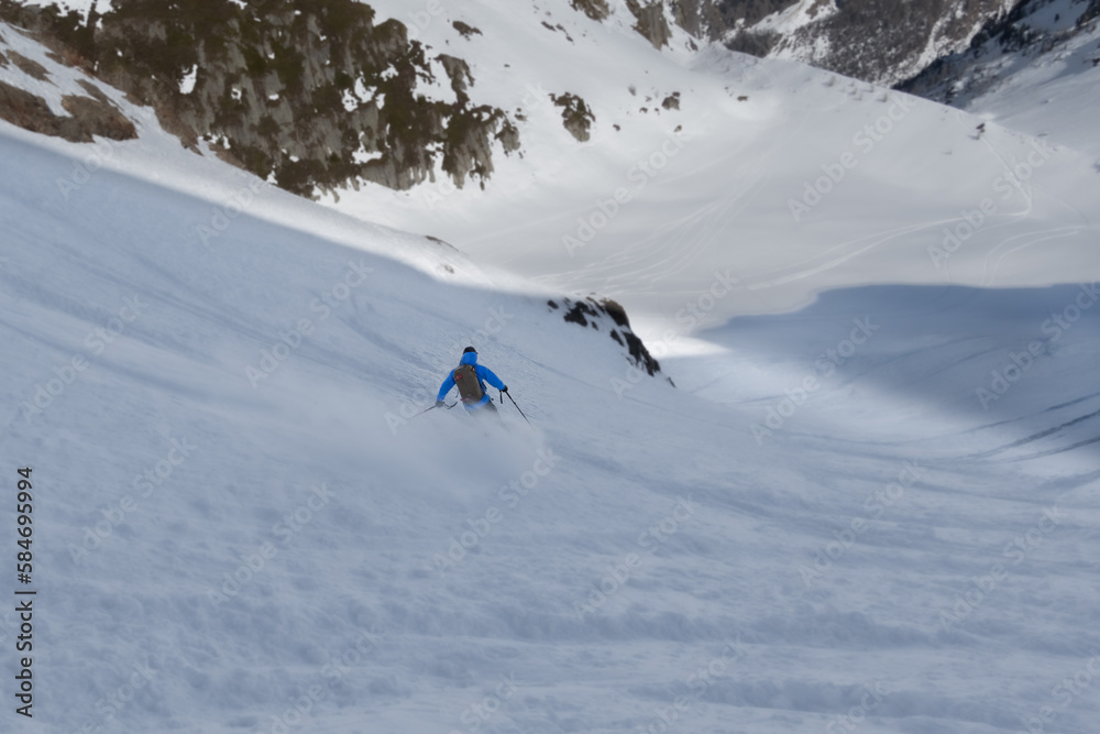 Single offpiste skier making fresh tracks in powder snow