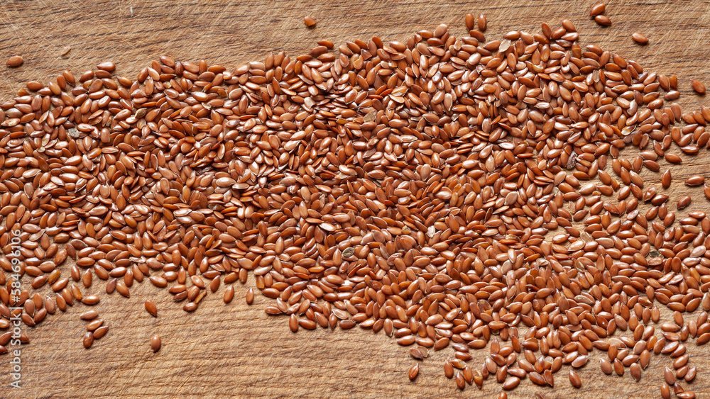 Obraz premium Flax seeds. Flax seeds are scattered on a wooden board. Omega 3. Healthy nutrition