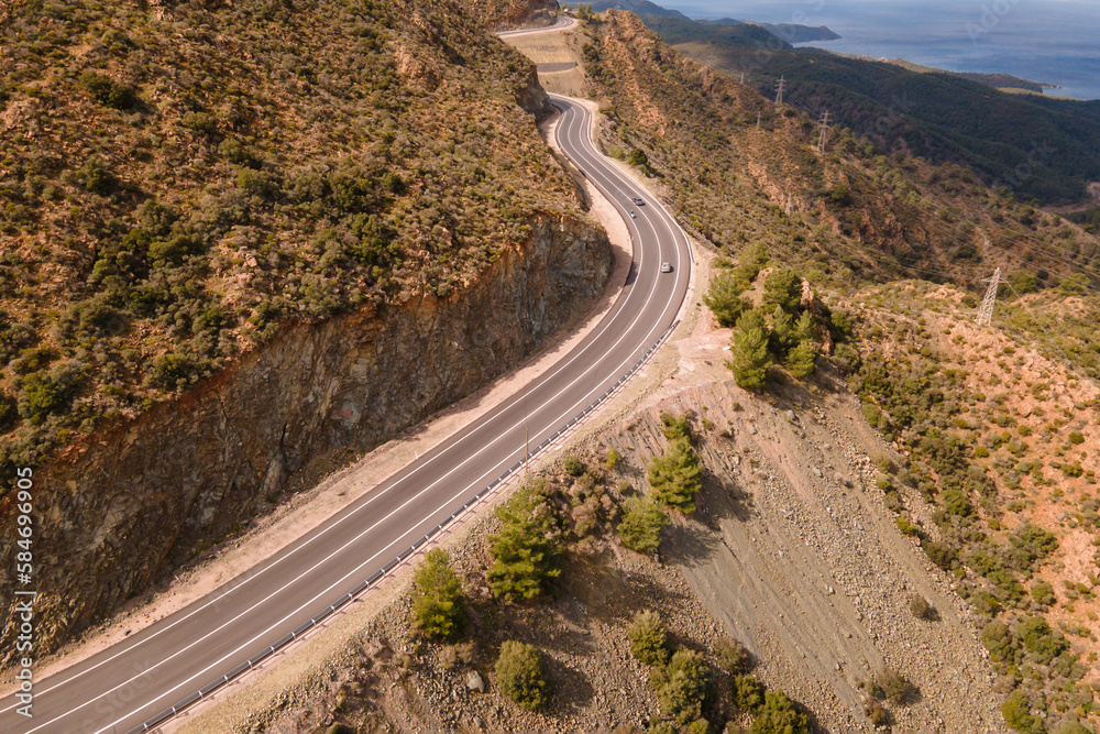 Scenic winding road in mountains, aerial wide shot