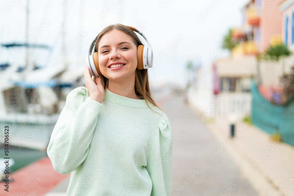 Young pretty blonde woman listening music