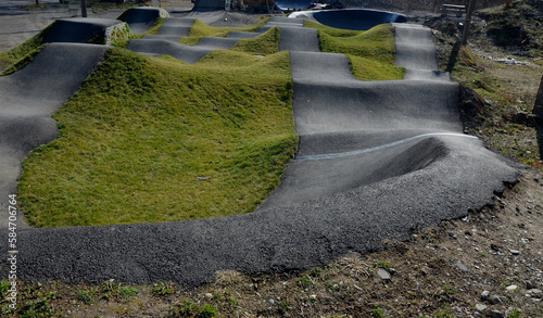 bike path in the car park Pumping (moving up and down) is used instead of pedaling and bouncing to move bicycles, scooters, skateboards and inline skates along the modular pumptrack track photo