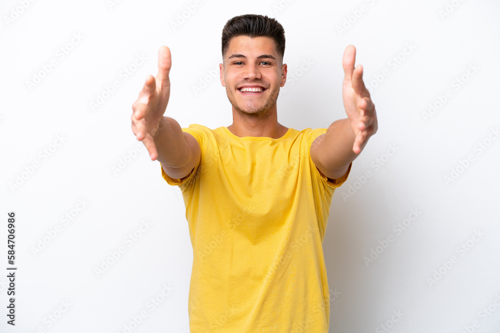 Young caucasian man isolated on white background presenting and inviting to come with hand Young caucasian man isolated on white background presenting and inviting to come with hand