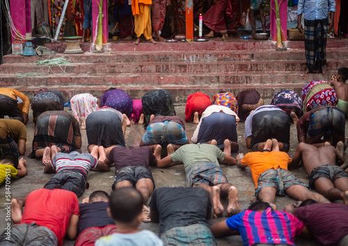 People showing salutations by falling prostrate before goddess durga in an religious festival for getting blessings 