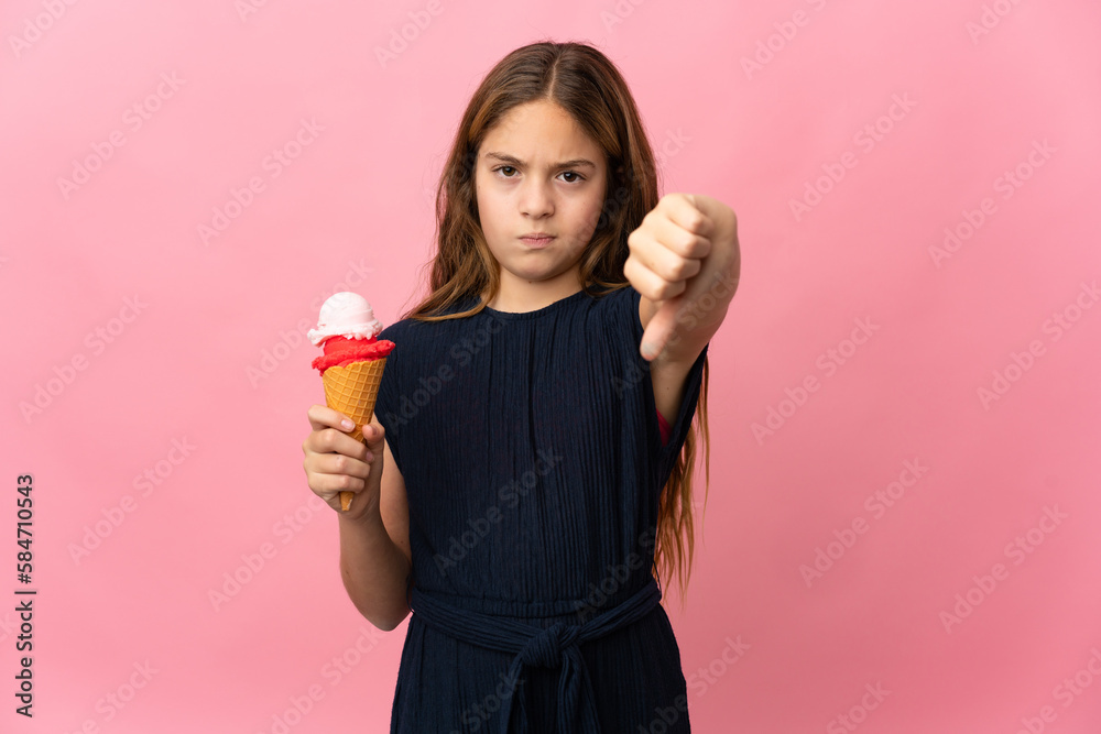 Child with a cornet ice cream over isolated pink background showing thumb down with negative expression Child with a cornet ice cream over isolated pink background showing thumb down with negative expression