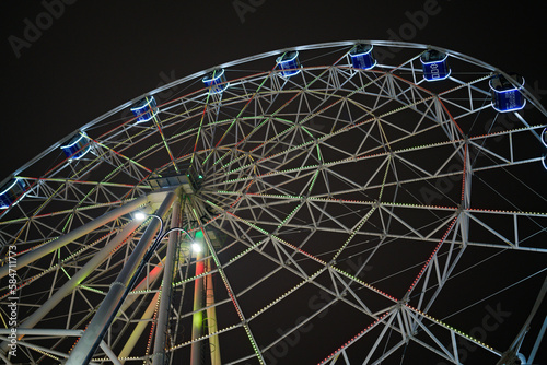 Ferris wheel in a night setting. Ferris wheel illuminated with colored lights.