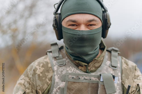 portrait of a military man in a balaclava with headphones. Military in camouflage. © Volodymyr