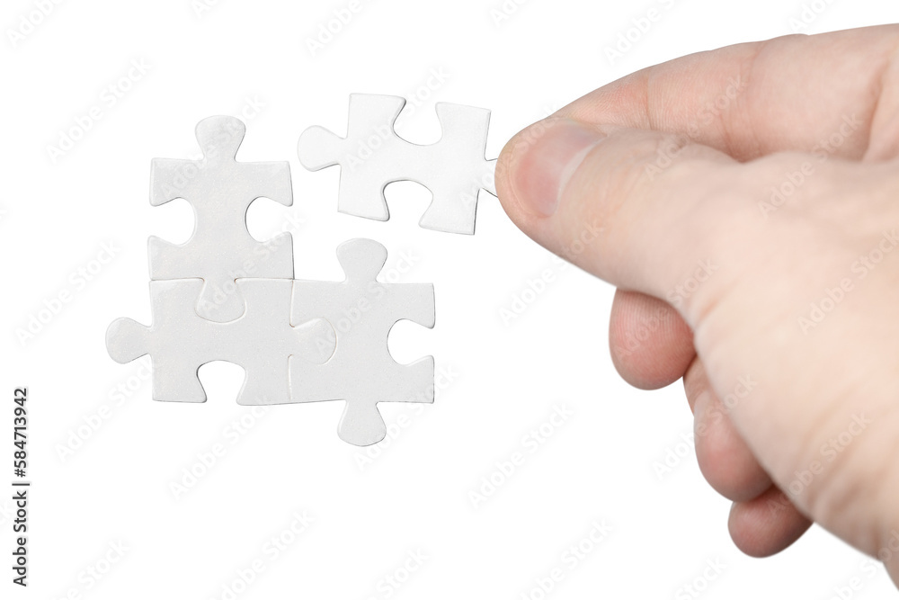 Hand inserting missing piece of puzzle, cut out Hand inserting missing piece of puzzle, cut out