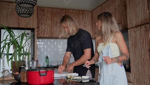 Happy love couple cook tasty food together home kitchen. Nice people bake diet cake. Fun lover use pot pan. Cute pair knead dough. Two baker make pie. Joy hipster family prepare bread meal indoor flat