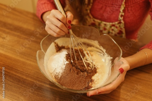 Close-up shot of mixing ingredients for making cakes, cookies or pastries. Detail images of beating butter, flour and eggs for dough making.
