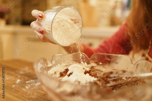 Close-up view of adding flour to pastry dough. The moment when the flour is poured while the cookie dough is being prepared.