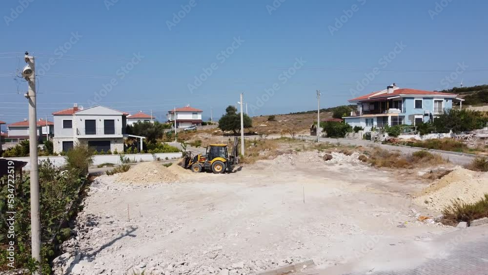 House construction in Turkey - A family house : summer house is built near Izmir. A bulldozer levels the plot of land House construction in Turkey - A family house : summer house is built near Izmir. A bulldozer levels the plot of land