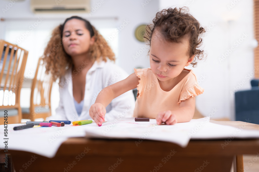 A little child's imagination is represented through colored pencil drawings, with the mother attentively supervising in the living room of the house. A little child's imagination is represented through colored pencil drawings, with the mother attentively supervising in the living room of the house.