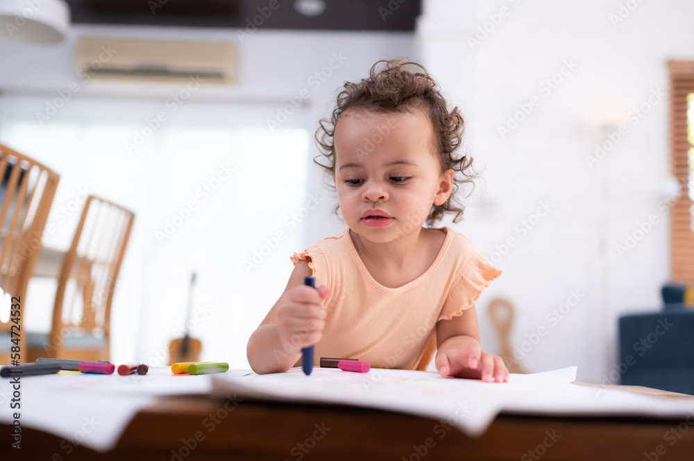 A little child's imagination is represented through colored pencil drawings, with the mother attentively supervising in the living room of the house. A little child's imagination is represented through colored pencil drawings, with the mother attentively supervising in the living room of the house.