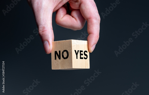 Symbol for the decision between yes and no. Wooden cube with the words 'yes' and 'no'.