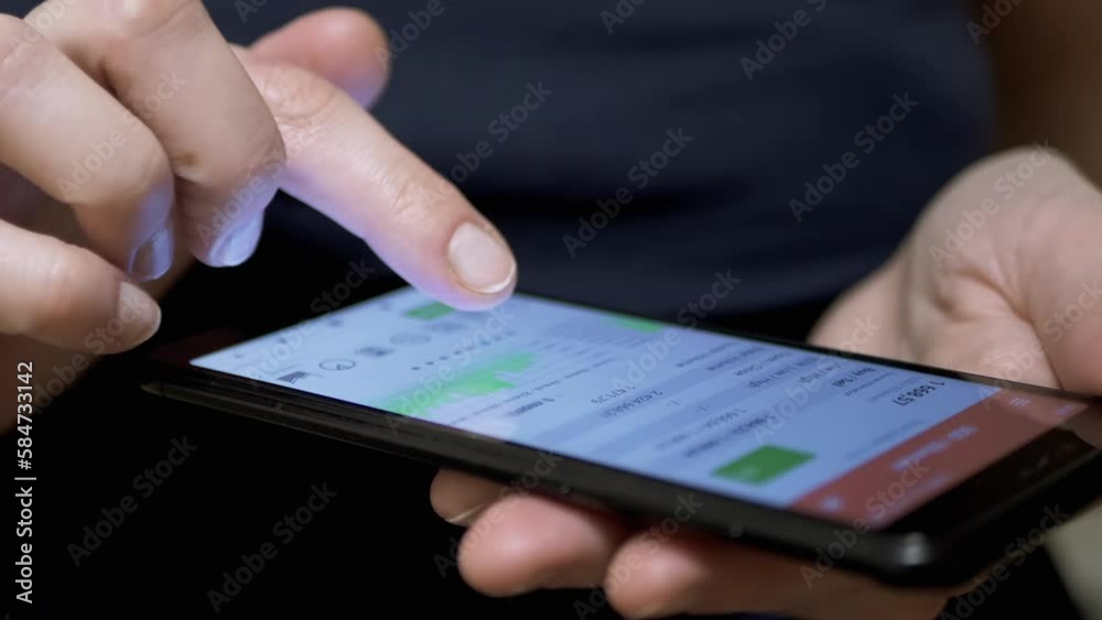 Trader Viewing Cryptocurrency Chart on Touchscreen in Mobile Phone. Business Woman touches smartphone screen with finger. Chart of growth, fall of crypto. Dynamics. Stock exchange data in mobile App. Trader Viewing Cryptocurrency Chart on Touchscreen in Mobile Phone. Business Woman touches smartphone screen with finger. Chart of growth, fall of crypto. Dynamics. Stock exchange data in mobile App.