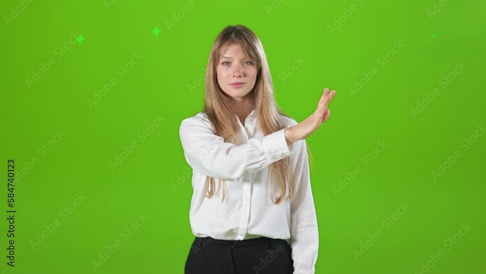Front view of focused, concentrated woman standing in studio, raising hand, scrolling. Attractive, blonde female looking at camera, smiling, Concept of modern lifestyle. Front view of focused, concentrated woman standing in studio, raising hand, scrolling. Attractive, blonde female looking at camera, smiling, Concept of modern lifestyle.