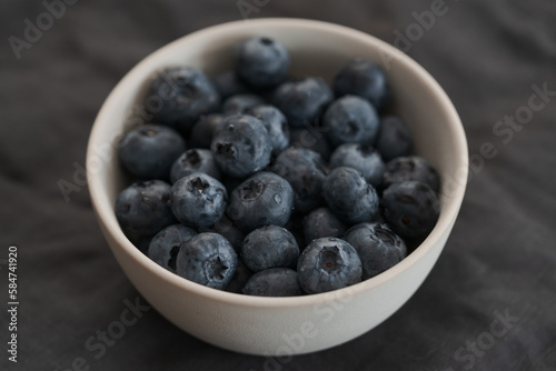 Fresh washed blueberris in white bowl on linen cloth