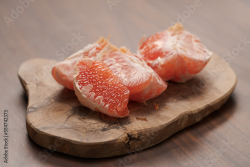 Peeled grapefruit on olive serving board