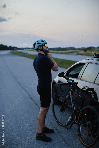 A young athlete cyclist takes off his equipment after training. The concept of active recreation and sports.