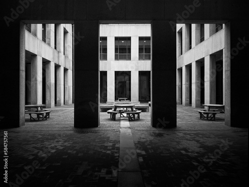 Black and white abstract of city architecture with benches for gatherings.