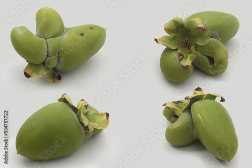 Four ugly and weird looking persimmons on white background photo