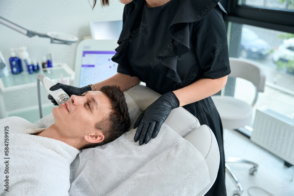 Cosmetologist doing facial skin rejuvenation procedure for male Cosmetologist doing facial skin rejuvenation procedure for male