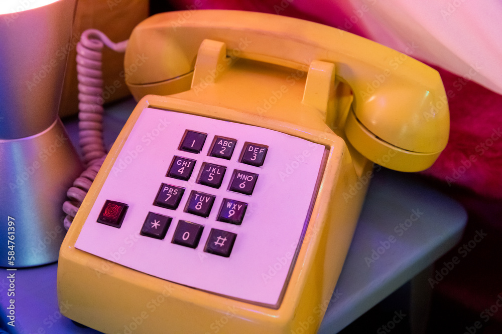 gros plan sur un téléphone jaune à boutons dans une ambiance rétro gros plan sur un téléphone jaune à boutons dans une ambiance rétro
