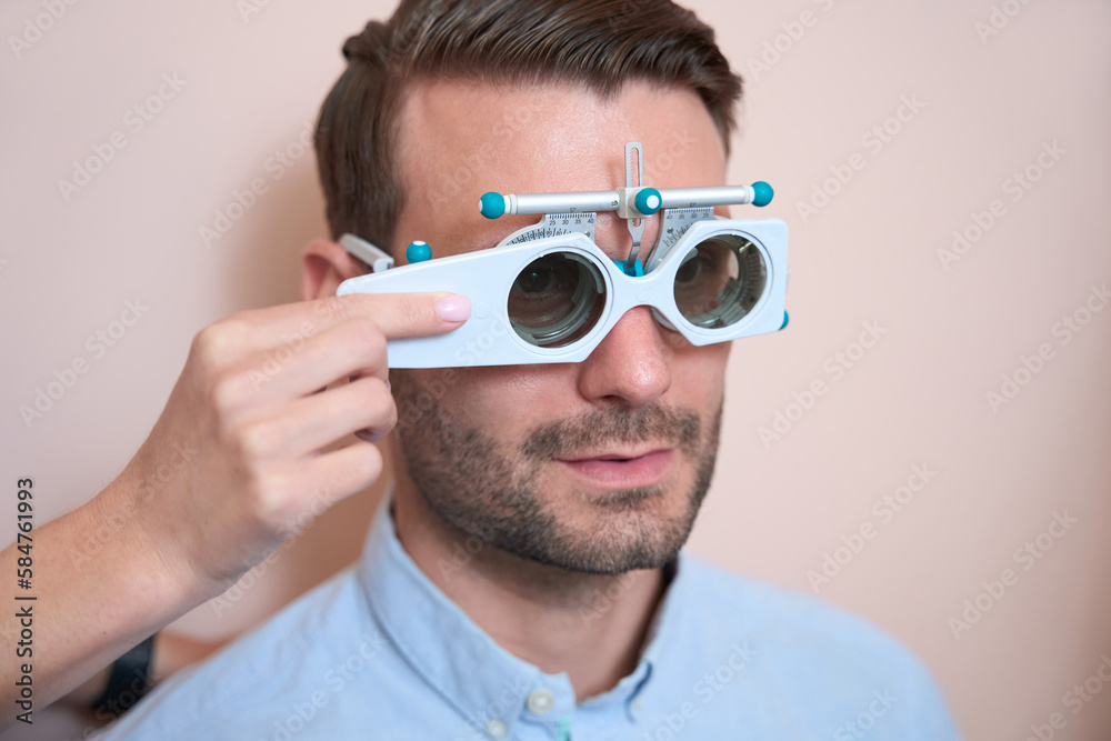 Adorable bearded male is checking his visual acuity is the ophthalmology center Adorable bearded male is checking his visual acuity is the ophthalmology center