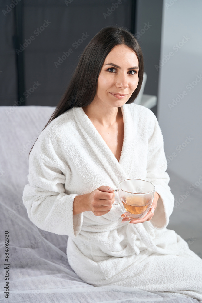 Portrait of young woman sitting on the bed