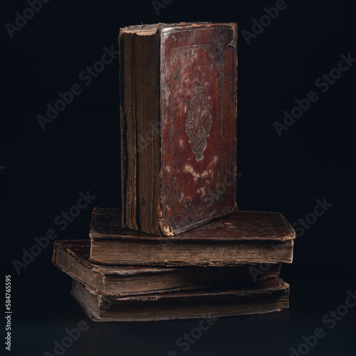 Obraz na płótnie Leather bound book with gold embossing. Torah book standing on stack of old jewish books in the dark. Education and religion concept. Low key. Closeup. w salonie