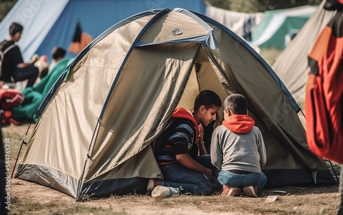 Young boys conversing next to a tent, depicting the life and struggles of refugee children.