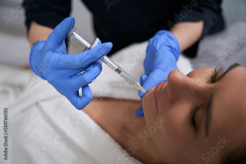 Cosmetologist doing anti-aging injections to beautiful client in salon