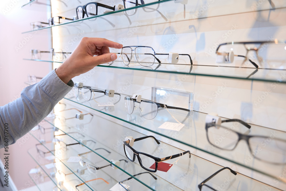 Unrecognized person is getting the stylish optician frame in the store