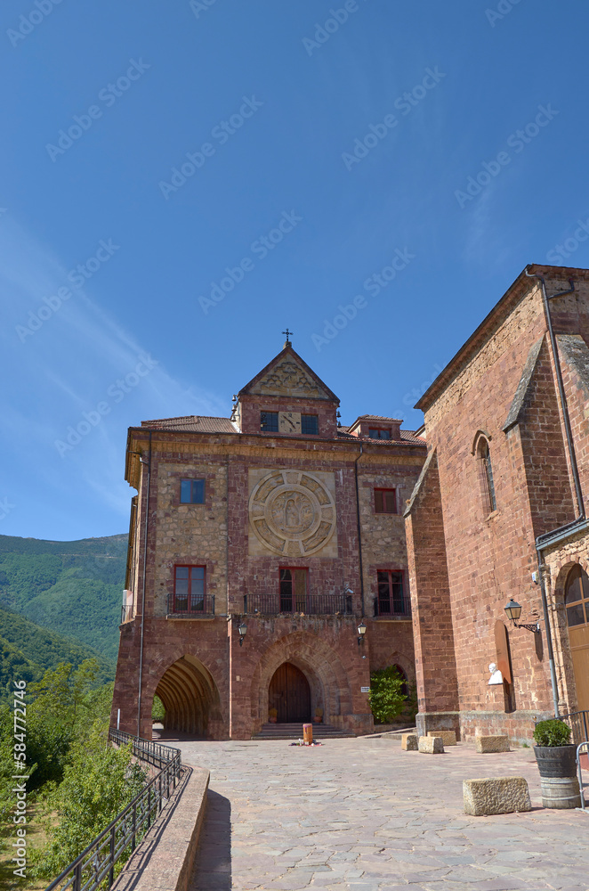 Mountain abbey with blue sky and green forest
