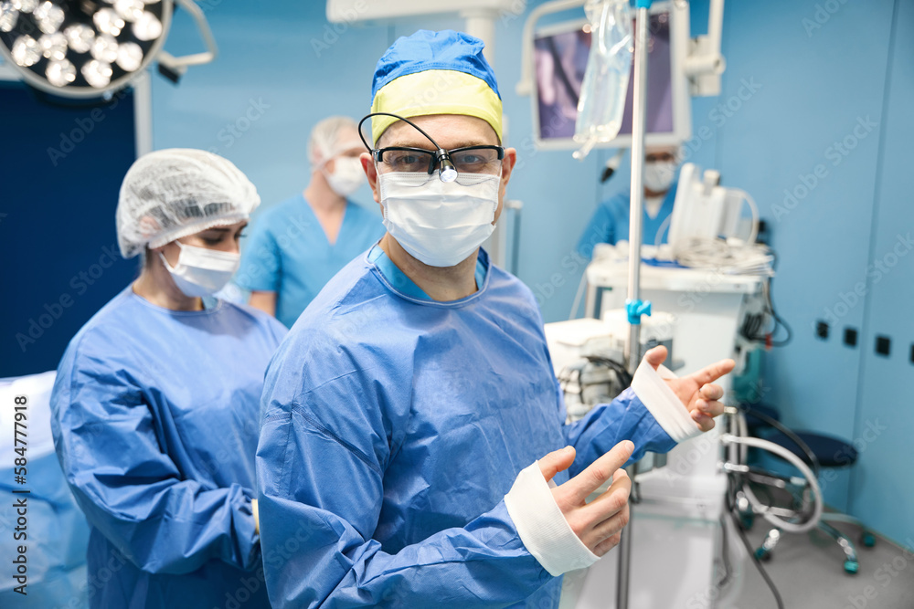 Surgeon is dressed in a sterile gown before the operation Surgeon is dressed in a sterile gown before the operation