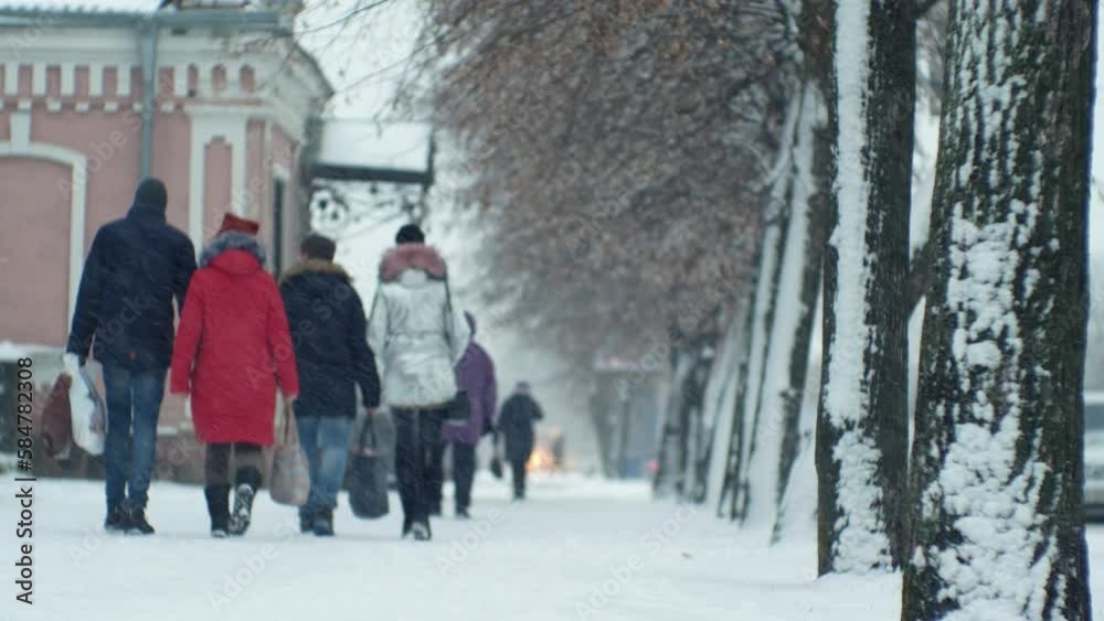 People pedestrians in a snowfall blizzard on a city street in cold winter Christmas weather People pedestrians in a snowfall blizzard on a city street in cold winter Christmas weather