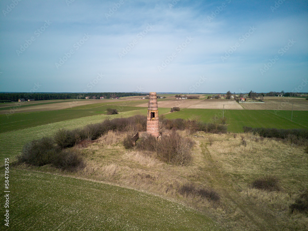 A lonely chimney and a stove in the middle of a field.
