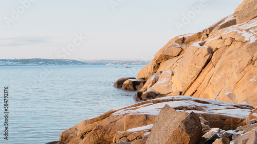 Calm ocean and snowy rocks background on the Norwegian coast by Folehavna, Sandefjord photo
