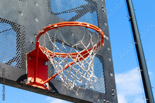 Fotografie Public city park basketball hoop closeup with black industrial metal backboard a