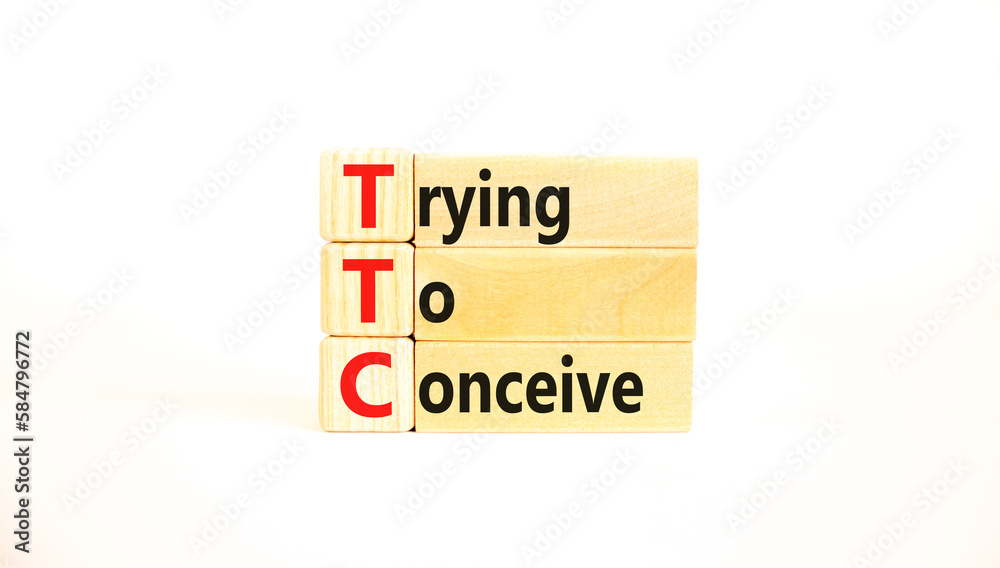 TTC trying to conceive symbol. Concept words TTC trying to conceive on wooden blocks on a beautiful white table white background. Medical and TTC trying to conceive concept. Copy space.